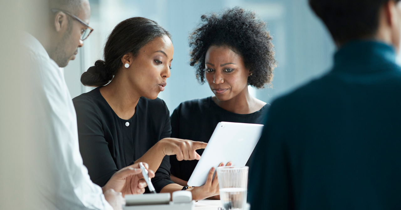 Two Black women work together in a professional setting. 