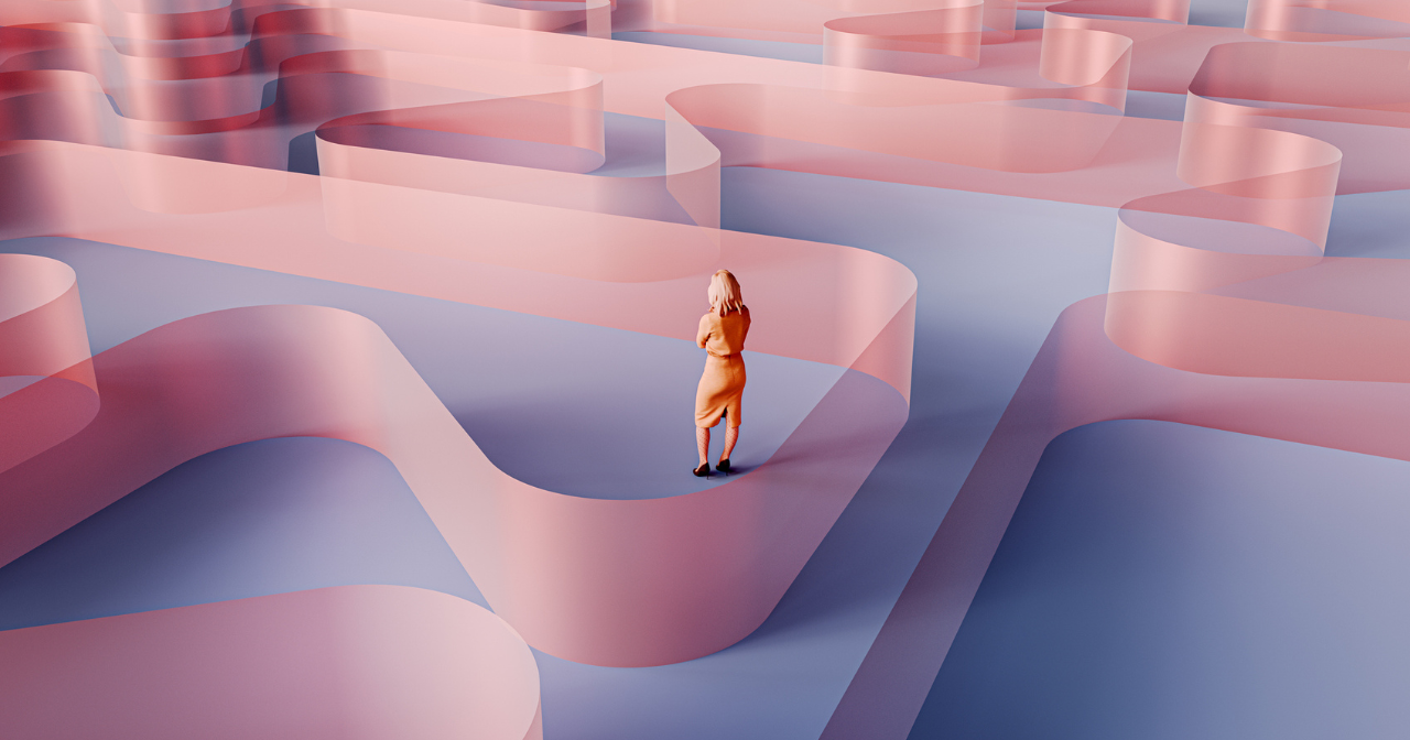 A woman stands in the midst of a large maze. 