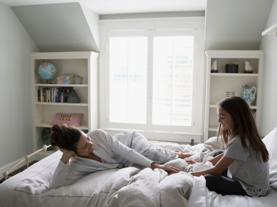 A mother and daughter in bed talking