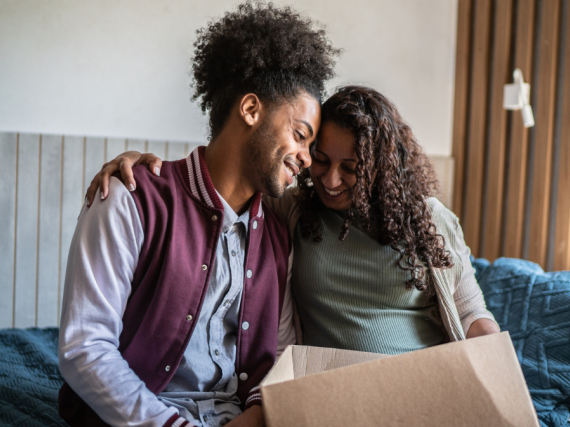 A mother and her son share a moment as they pack his things for him to move out of the house. 